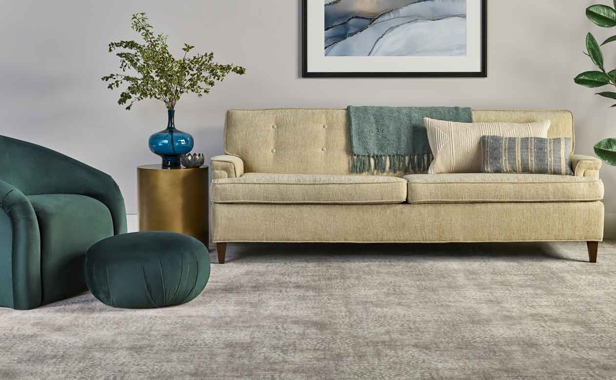 cozy living room with cozy grey carpets and green velvet accent chair